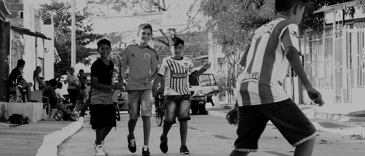 Cuatro niños caminando sonriente en una calle de Barranquilla.