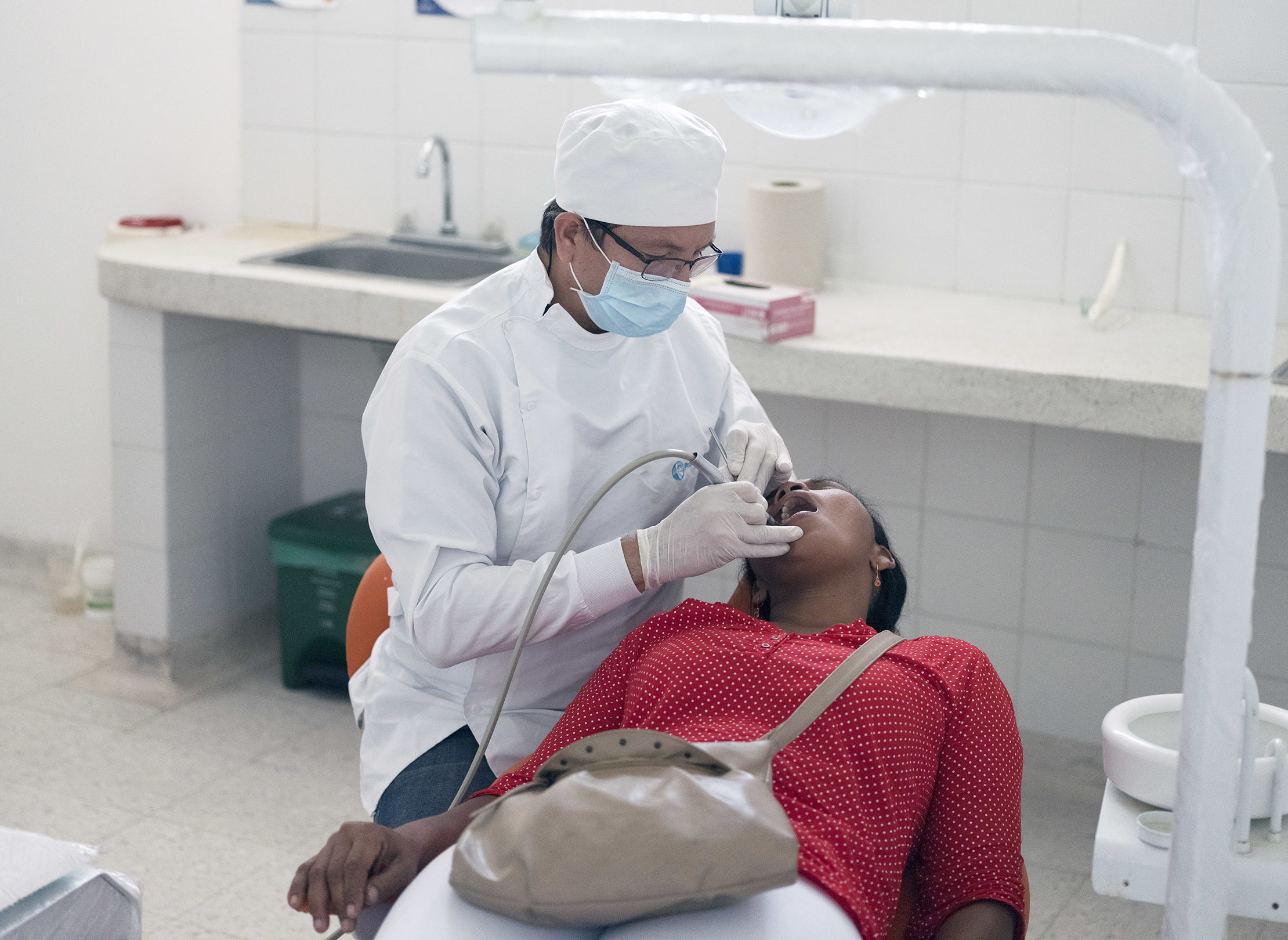 Odontólogo haciendo higiene oral a paciente