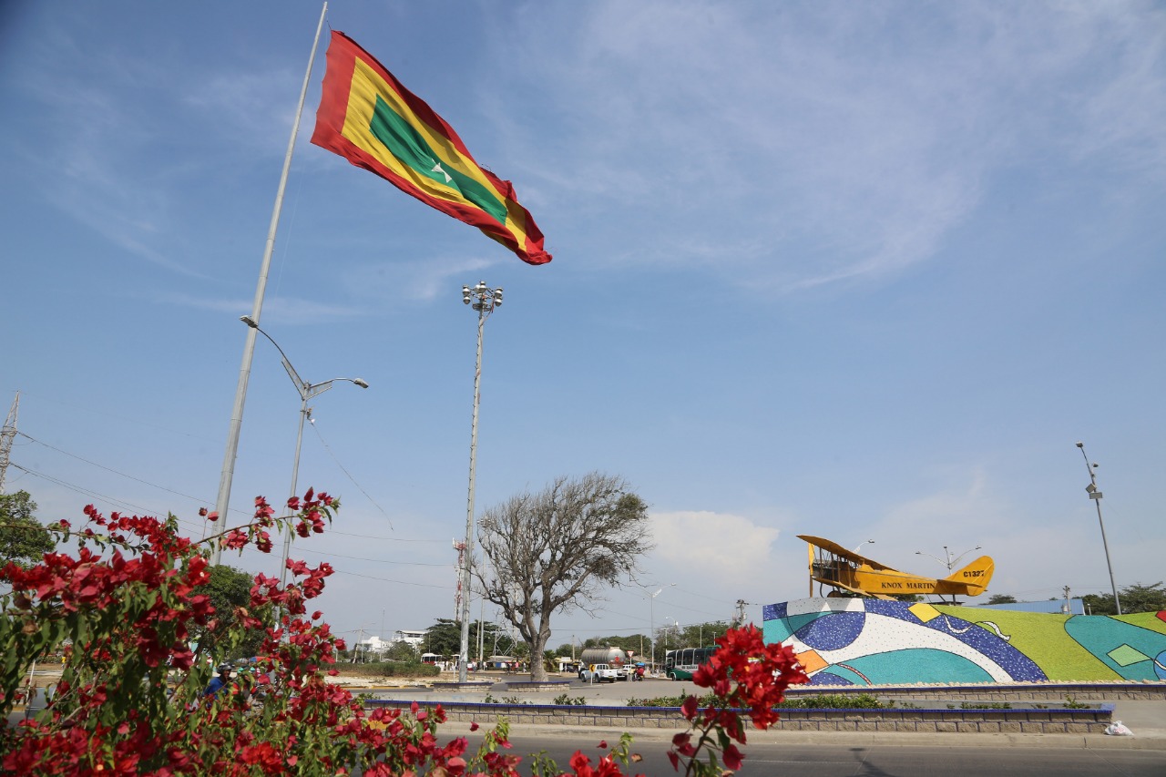 Vista de de un parque con la bandera de Barranquilla izada.