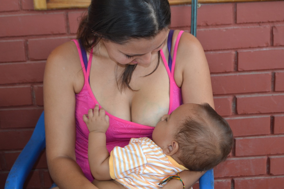 Mujer lactando a bebe en brazos