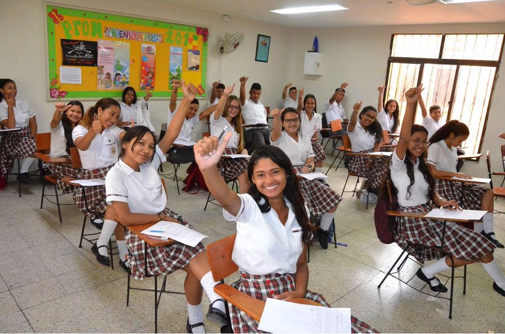 Estudiantes alzando la mano para foto