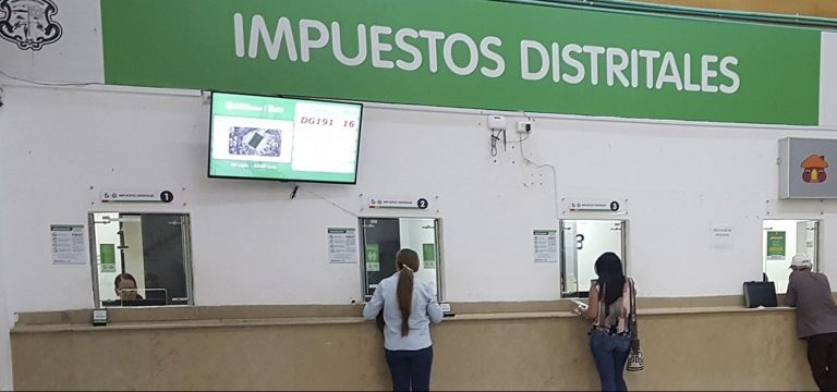 Dos personas haciendo trámites en la ventanilla de pago de la Alcaldía de Barranquilla.