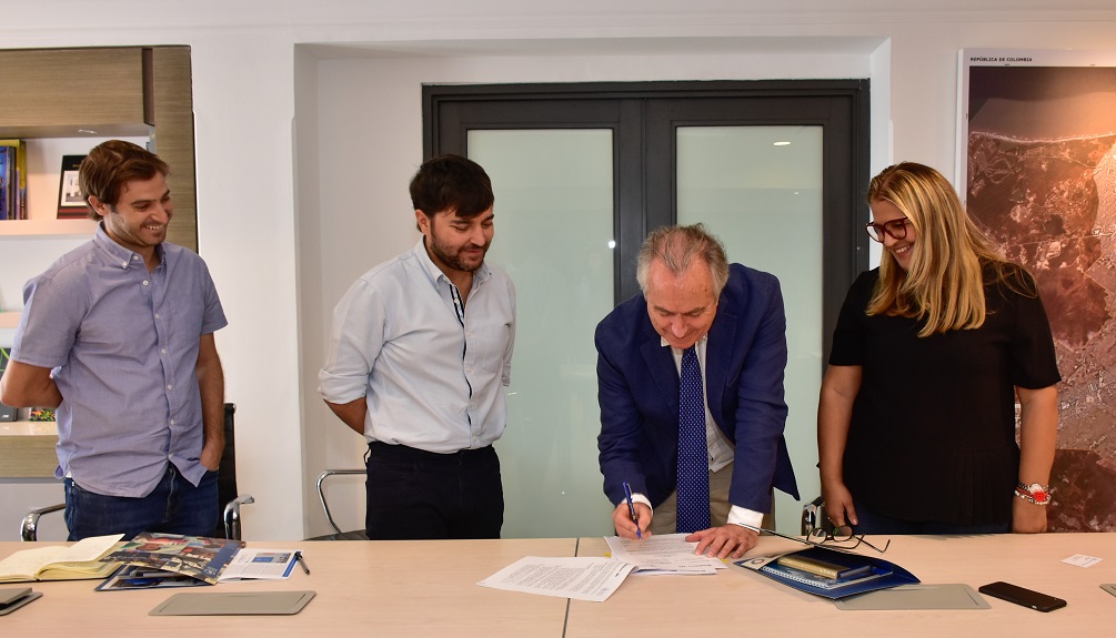 Alcalde y delegado de la ONU firmando acuedo