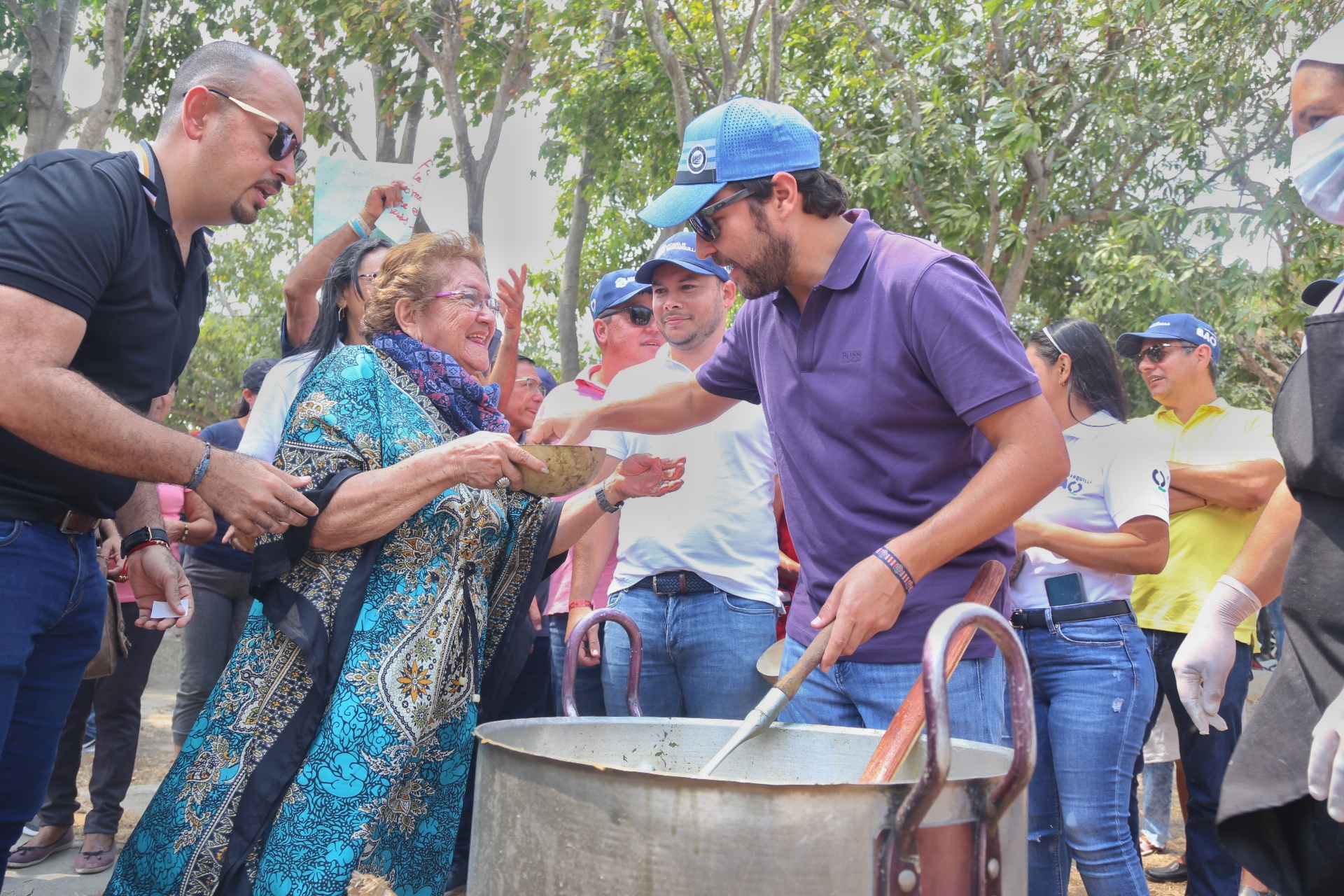 Alcalde repartiendo sopa a ciudadana