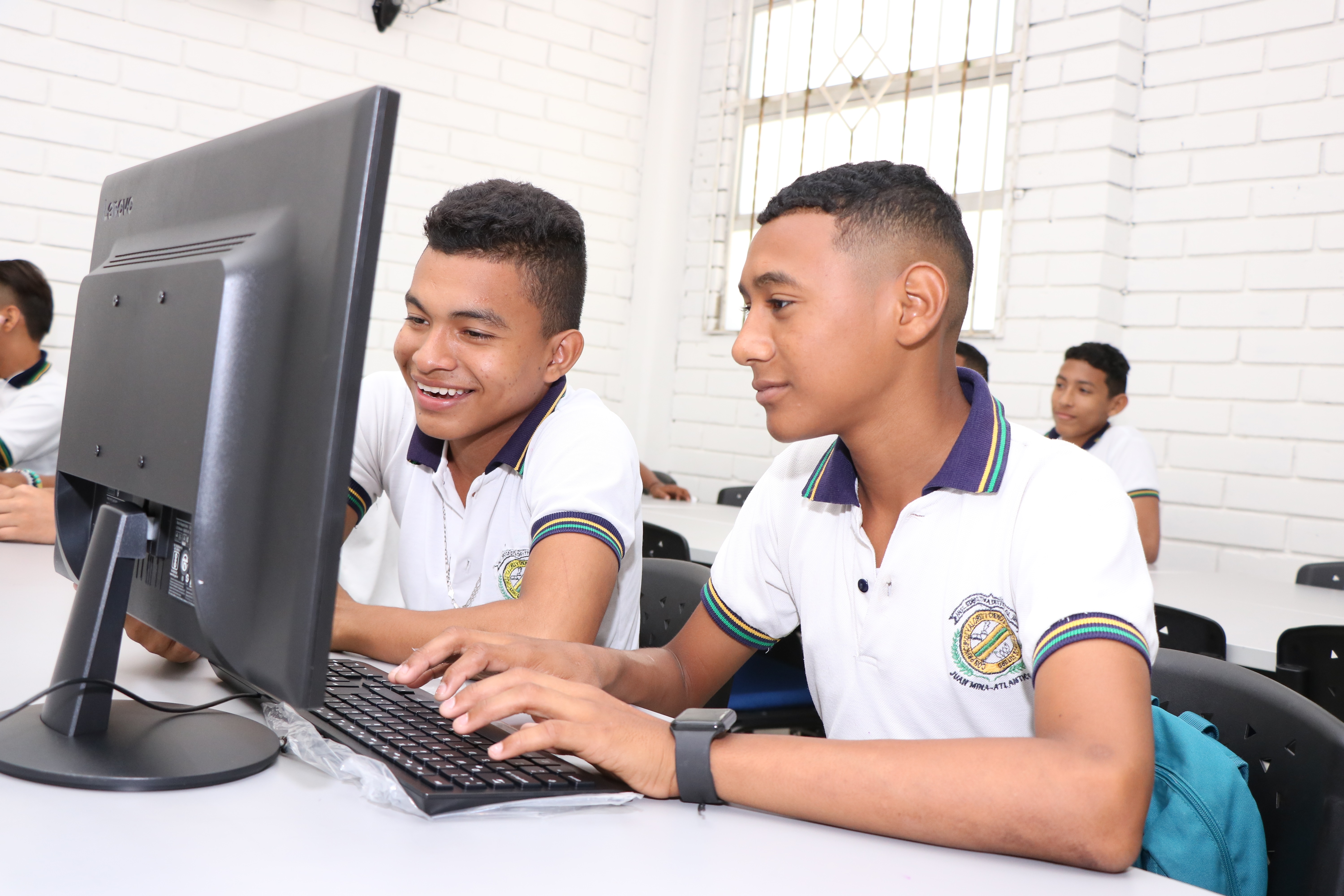 Estudiantes frente a pantalla de computador