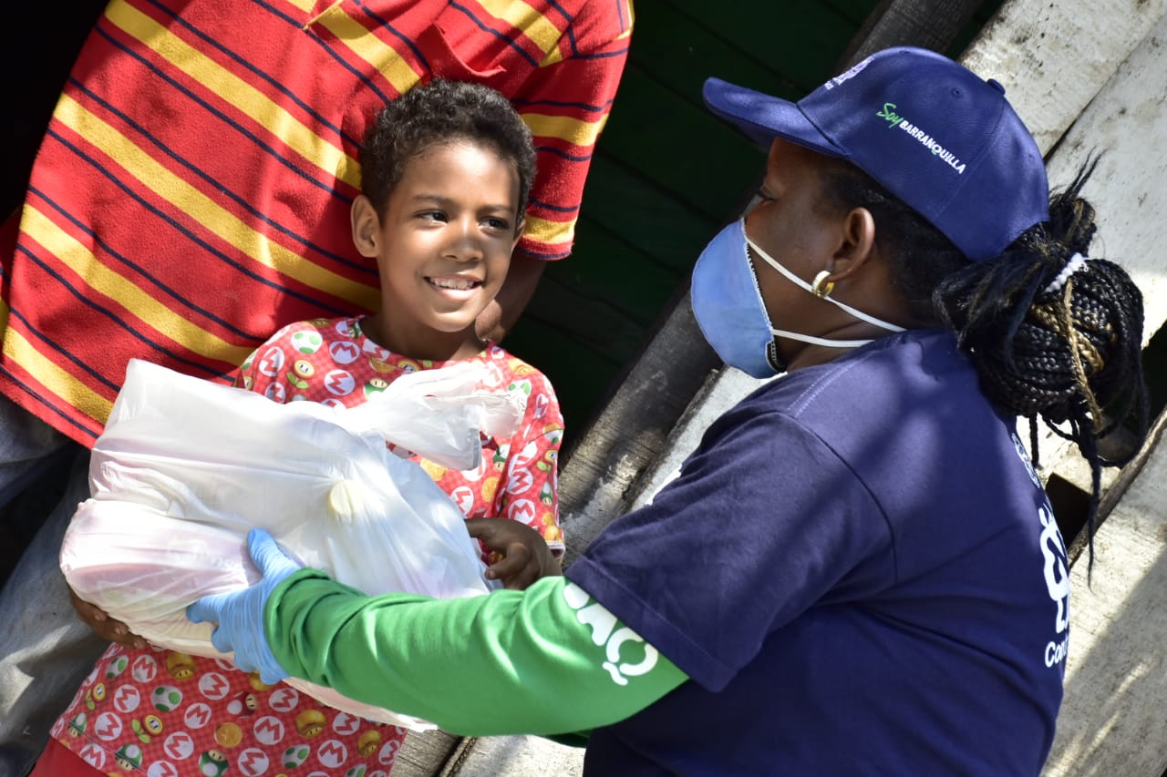 Brigadista de salud entregando auxilios a una menor