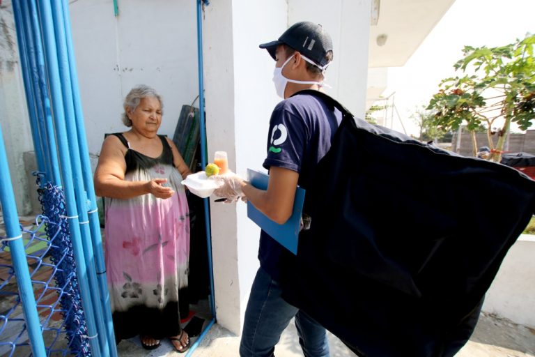 Funcionario haciendo entrega de alimentos a adulto mayor