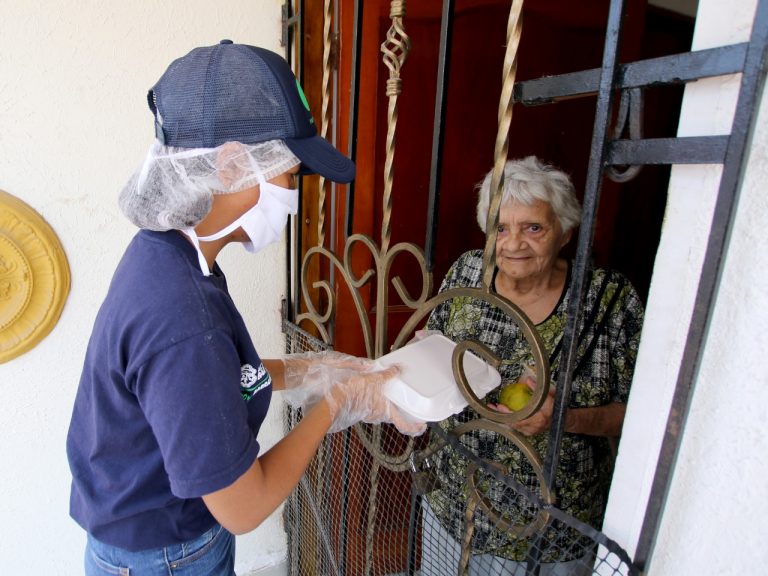 Funcionario haciendo entrega de alimentos a adulto mayor