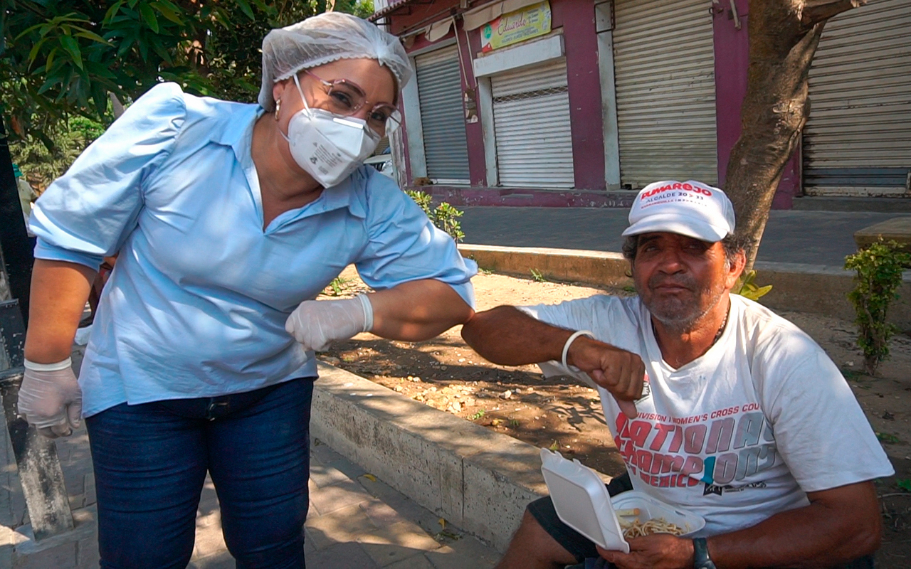 Saludo de codo entre funcionario y habitante de calle