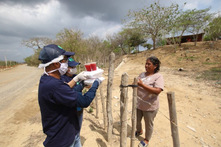 Brigadista de salud entregando alimentos a mujer en zona rural