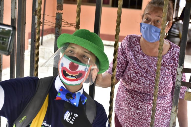 Clown en terraza de vivienda frente a adulto mayor