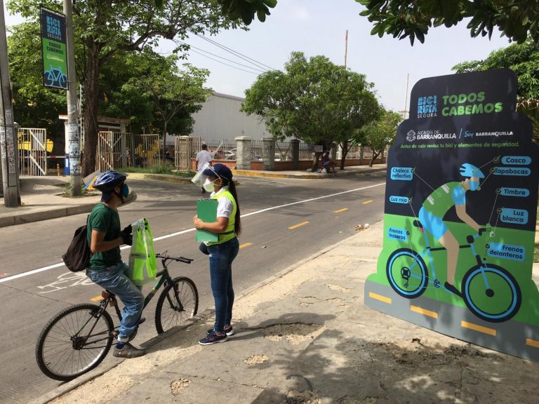 Persona en Bicivcleta siendo informada por brigadista de salud