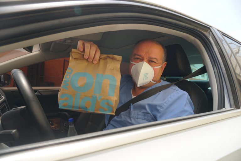 Conductor de vehiculo mostrando una bolsa de McDonalds