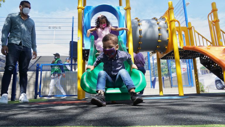 niños en resbaladero de parque 