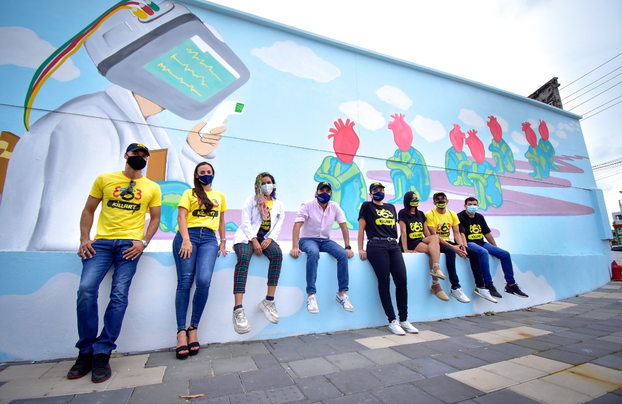 Jóvenes sentado al lado de mural