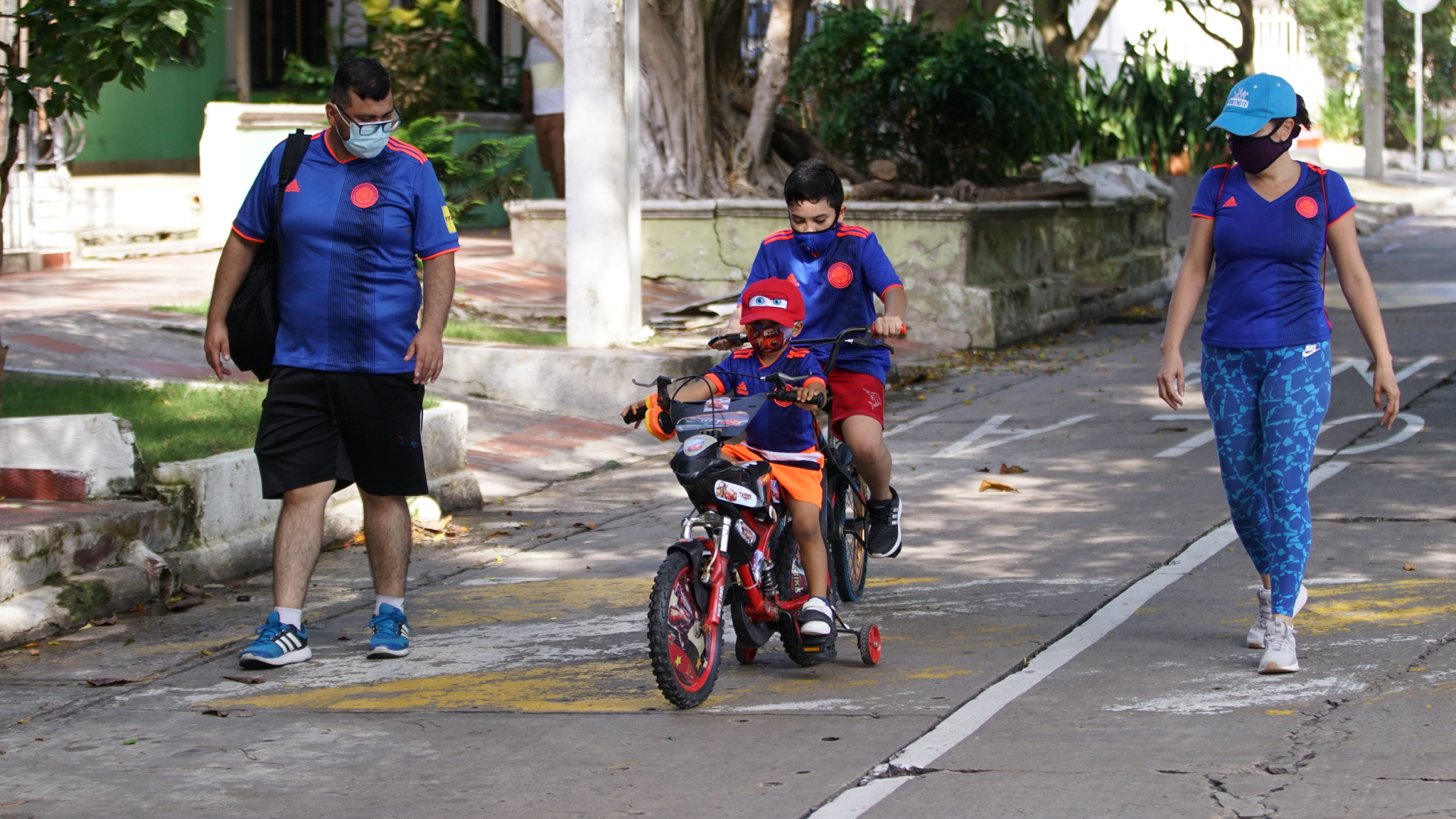 Niño en bicicleta acompañado de padres