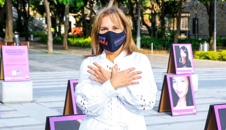 Jefe oficina de la mujer con fotos de mujeres violentadas