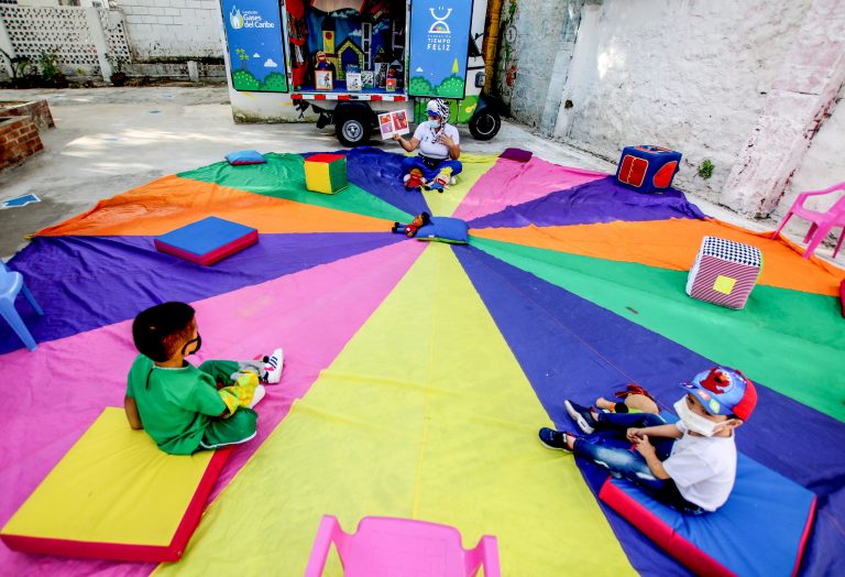 Niños juegan en una manta colorida en un área de juegos