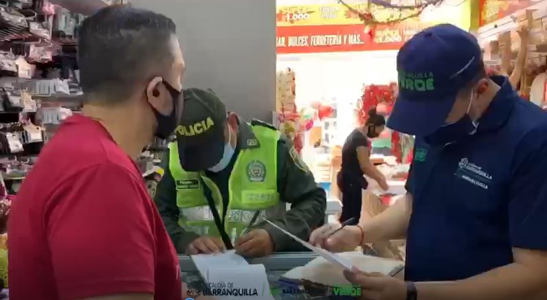 Funcionarios y policía realizando comparendo en establecimiento