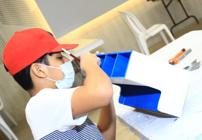 Niño pintando caja de azul