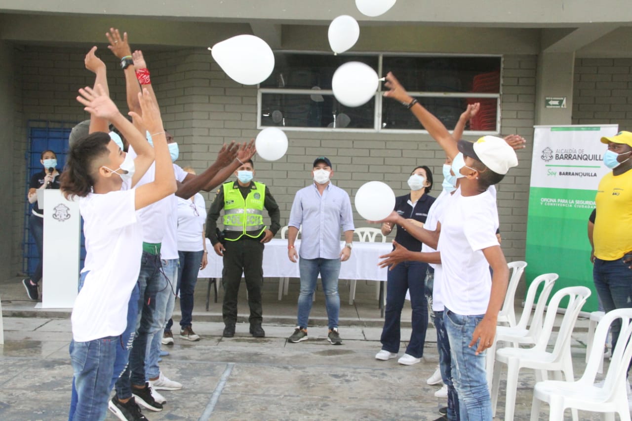 Jóvenes tiran globos blancos