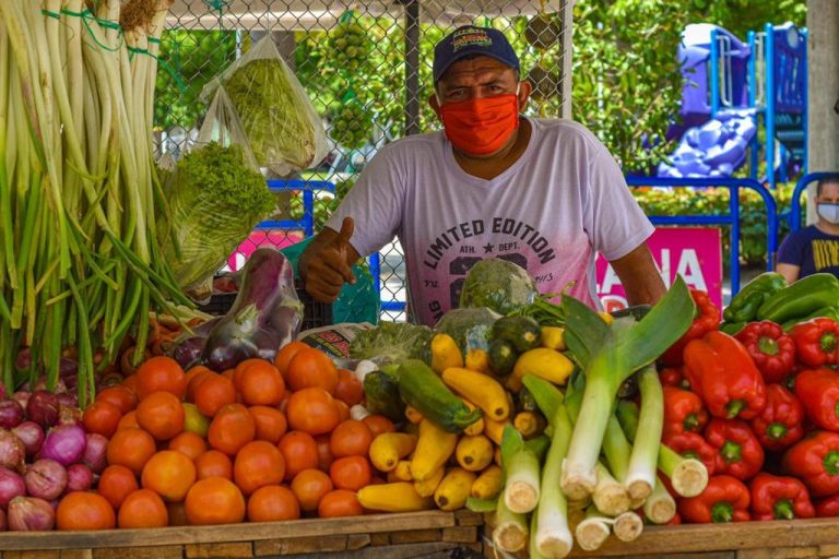 Hombre posando con verduras y frutas