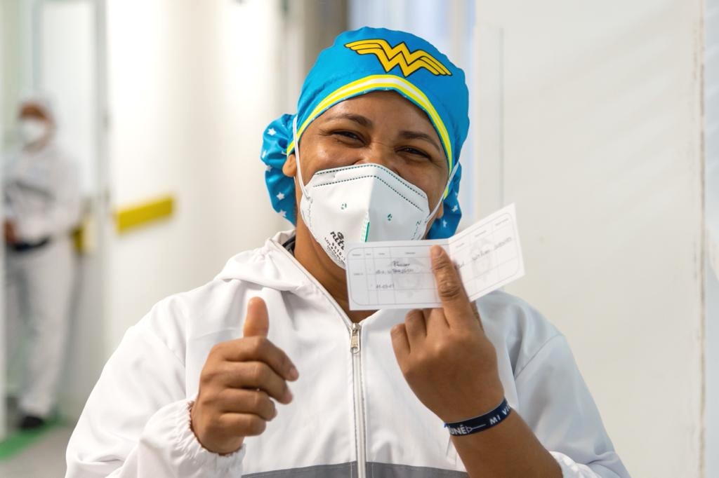 Mujer mostrando carnet vacunas