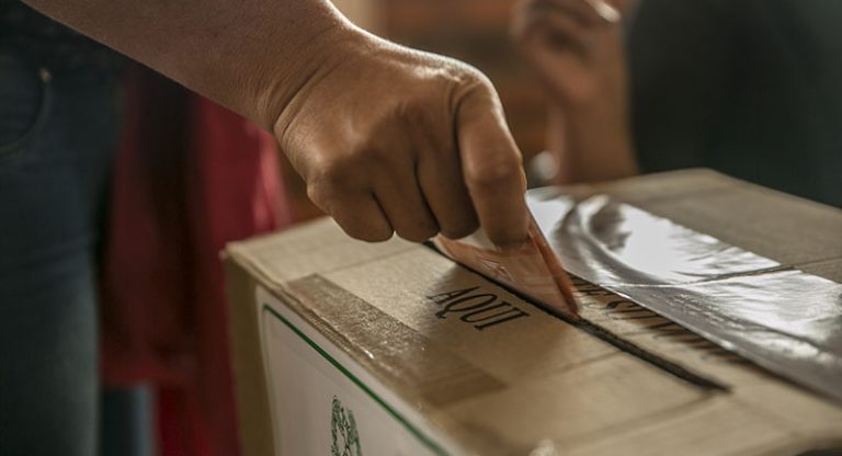 Persona ingresando su voto a la urna