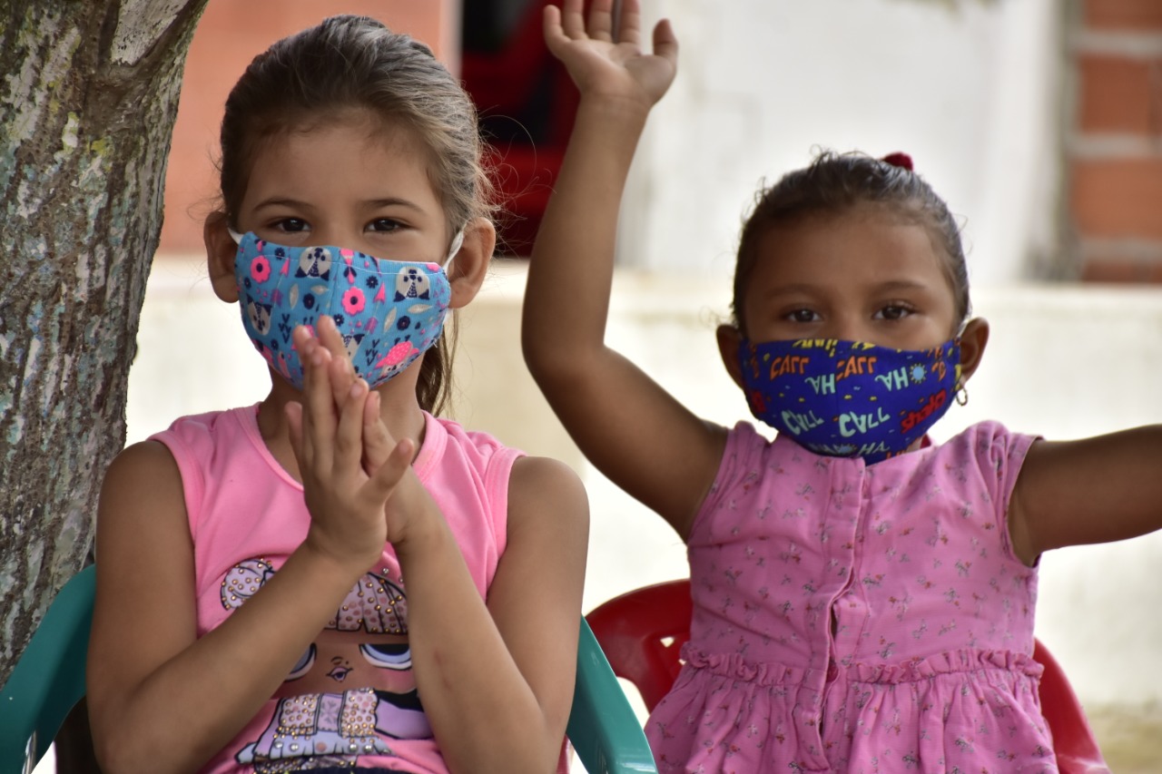 Niñas con mascarillas sentadas