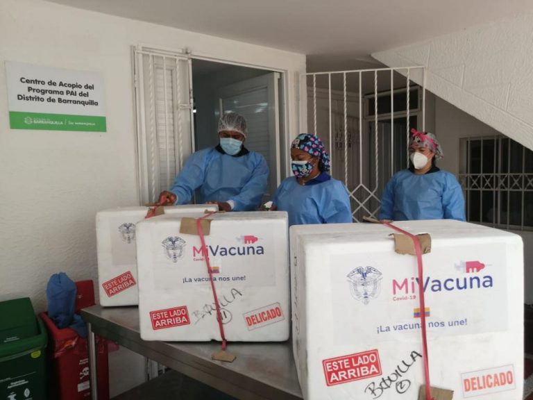 Personal de la salud con lotes de vacunas