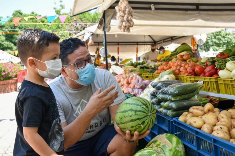 Hombre y niño con mascarillas en un mercado a tu barrio