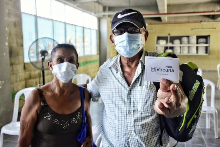 Adultos mayores mostrando carnet de vacunación