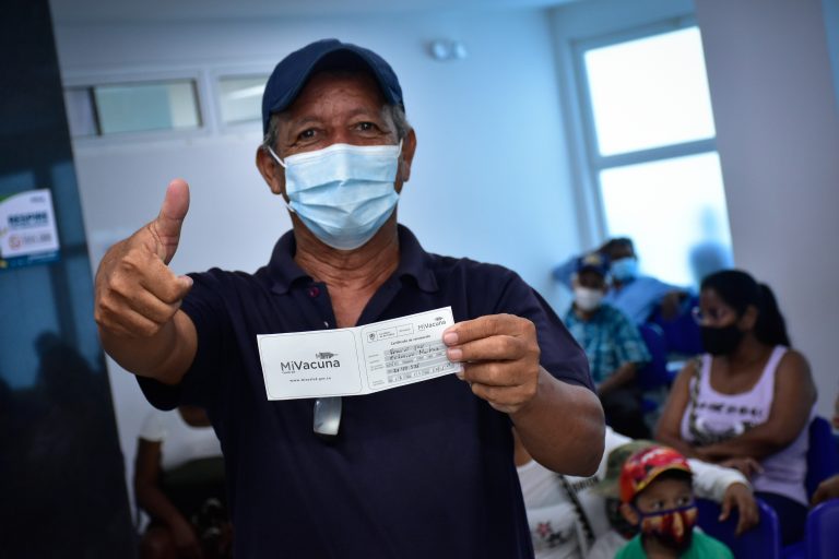 Hombre mostrando carnet vacunación