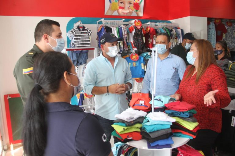 Funcionarios y policia visitando a comerciantes.