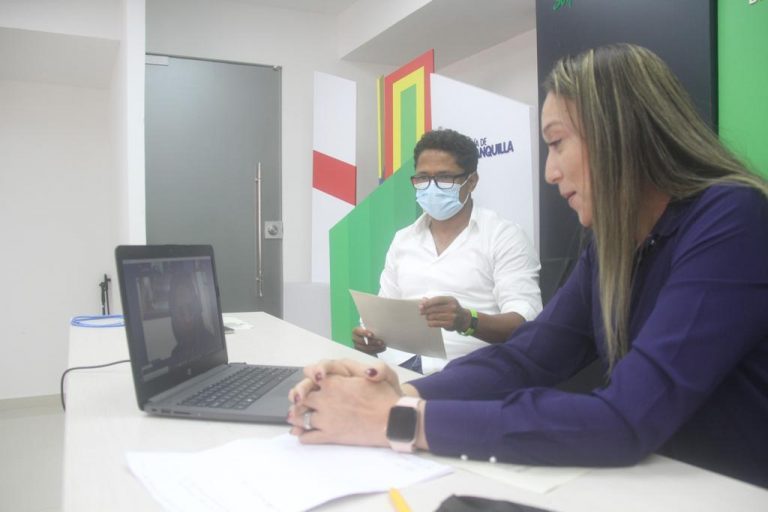 Mujer frente a un computador recibiendo capacitación