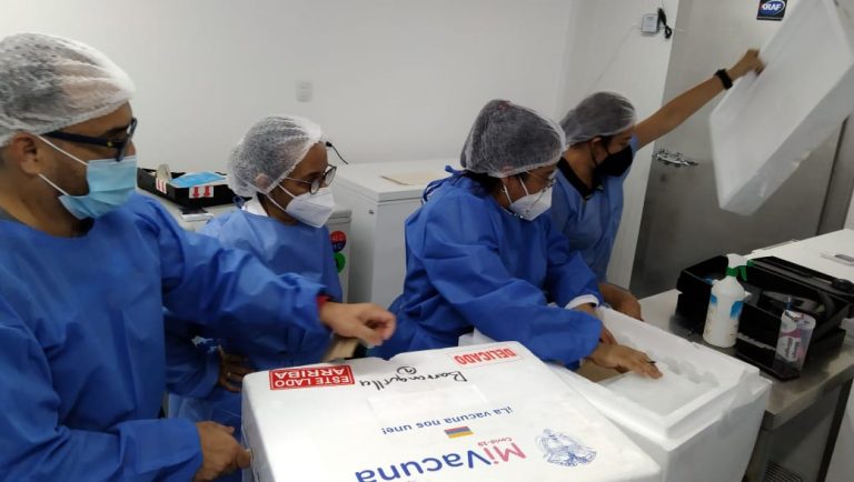 Personal de la salud revisando cajas con vacunas.