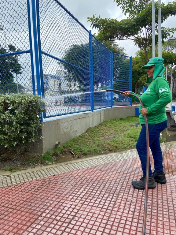 Dora Muñoz, regando las plantas en parque.