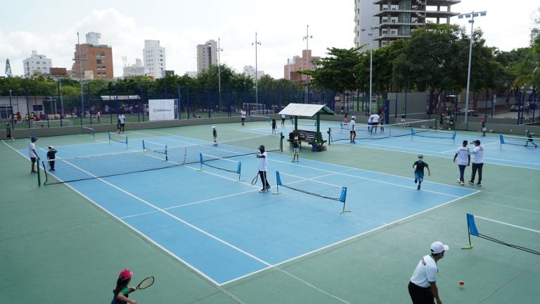 Deportistas jugando en cancha de tenis