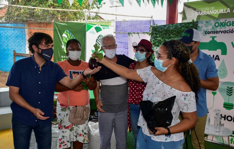 Alcalde Jaime Pumarejo recibiendo verduras sembradas por la comunidad.