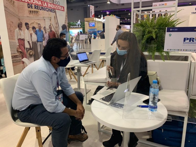 Jefe de la Oficina de Turismo, Kathy López, con visitante de la feria