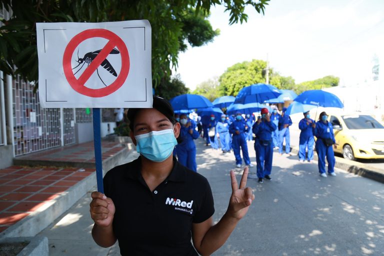 Funcionaria con cartel de no mosquito.