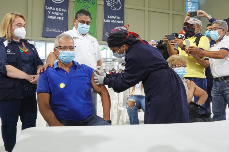 Funcionaria de salud vacunando ciudadano.