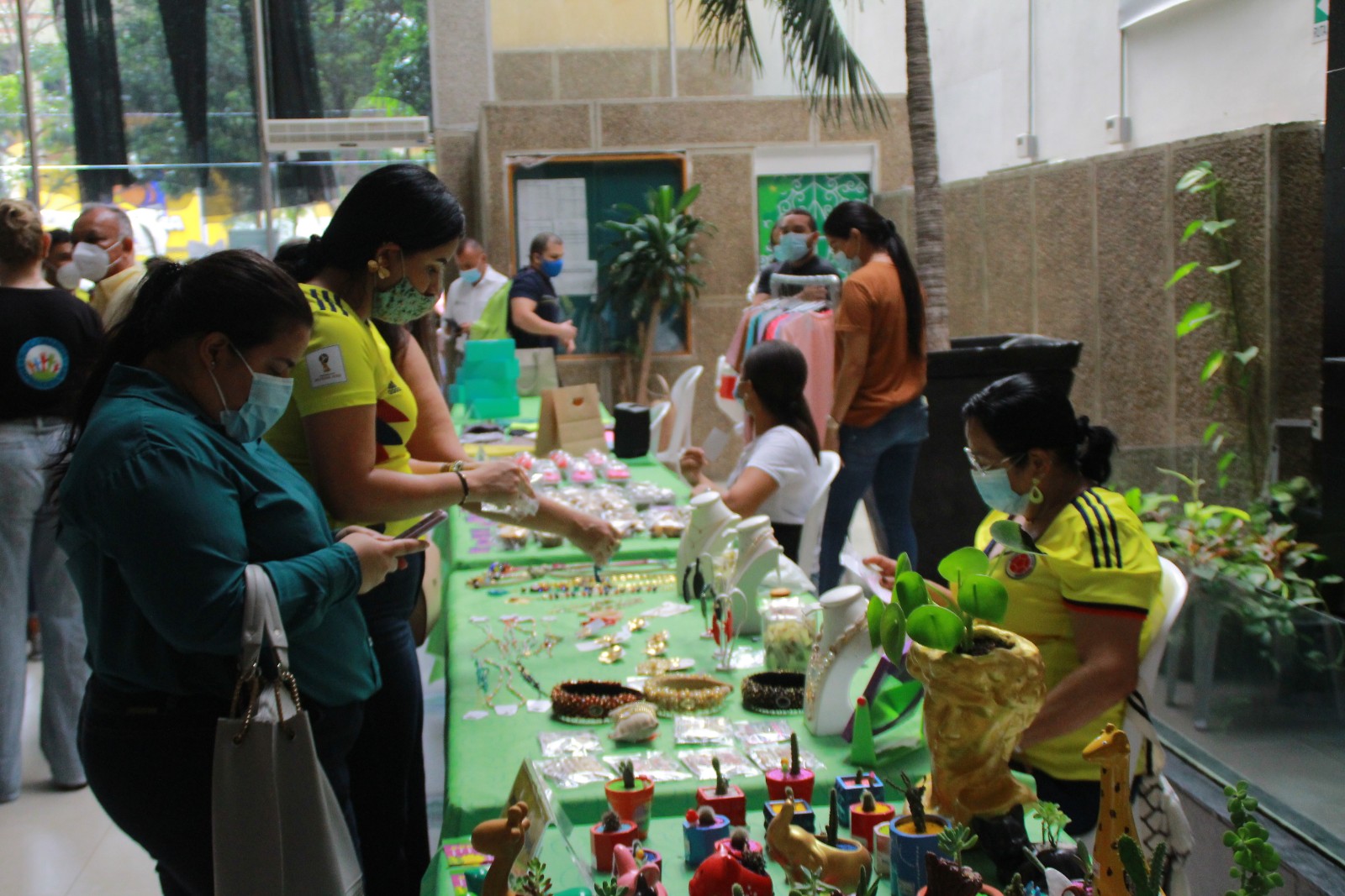 mujeres observando estands de emprendimientos al interior de la Alcaldía