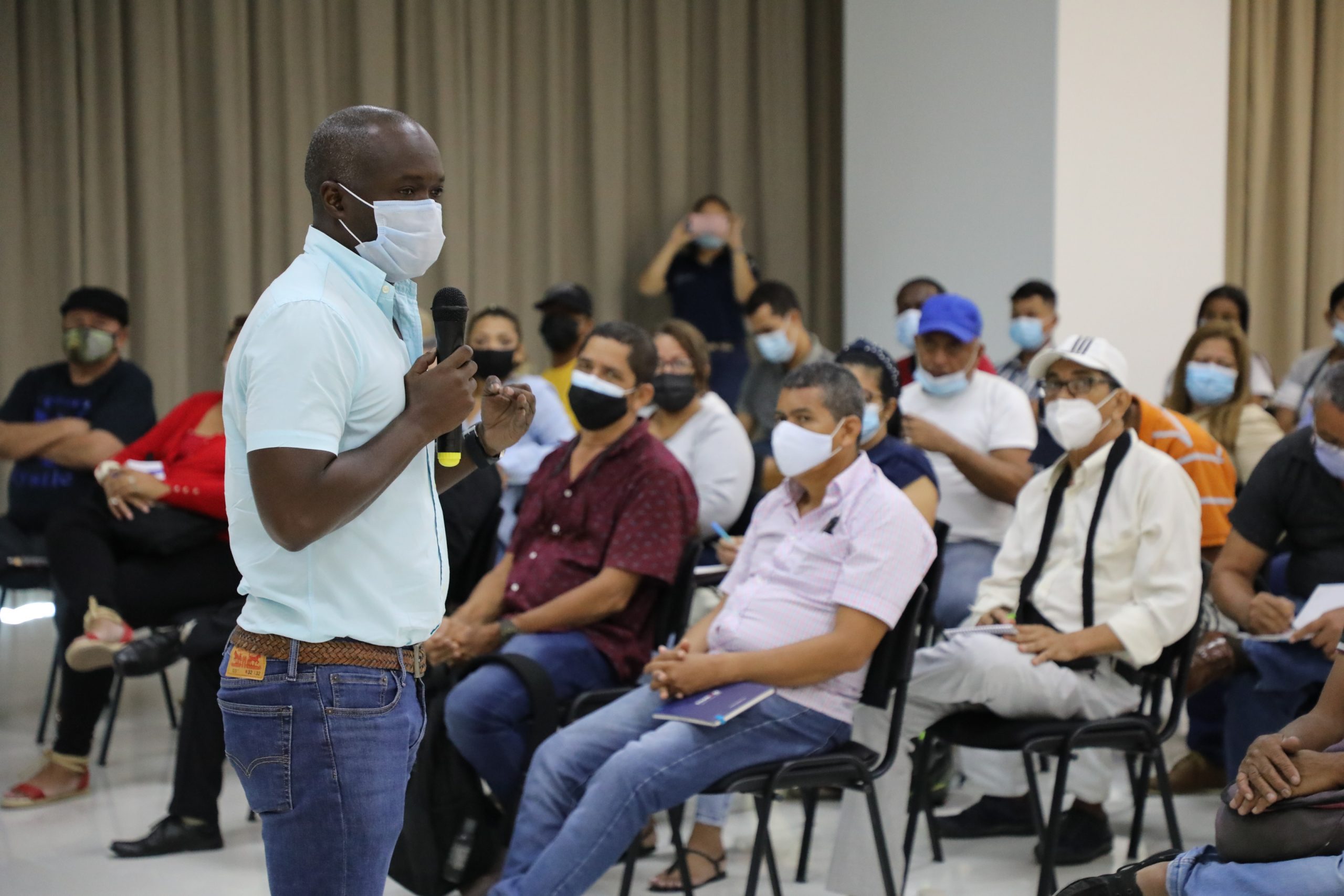 Deivy Cásseres dirigiéndose a público en auditorio.