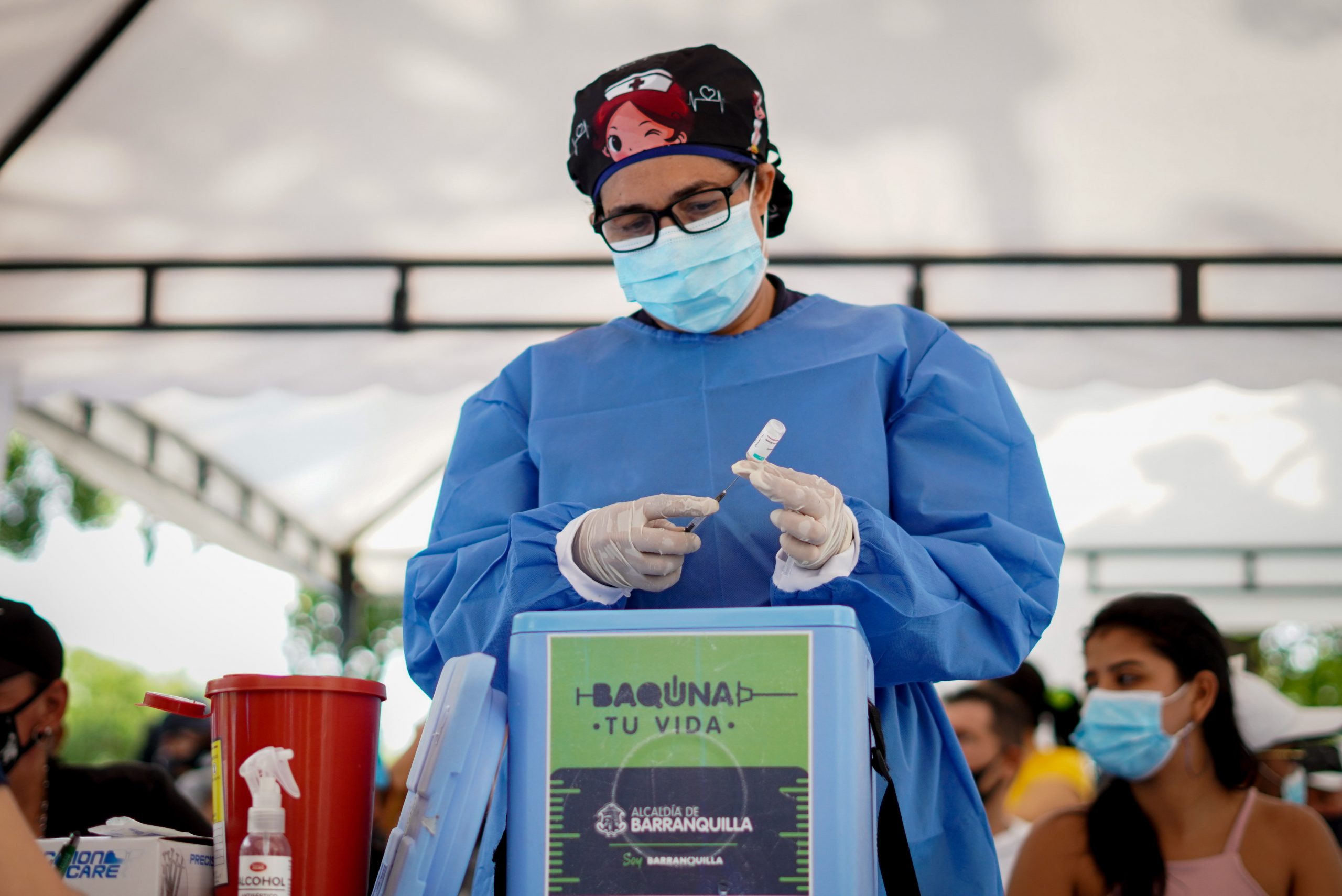 Funcionaria de salud preparando jeringa con vacuna.