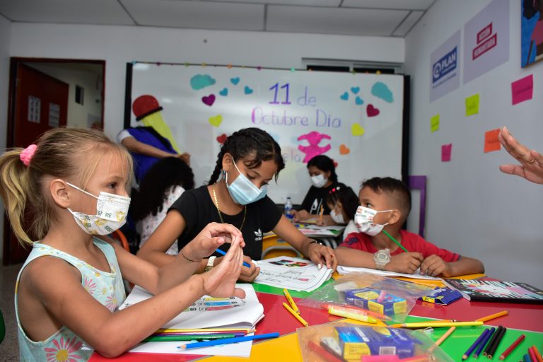 Niños dibujando en salón de clases.