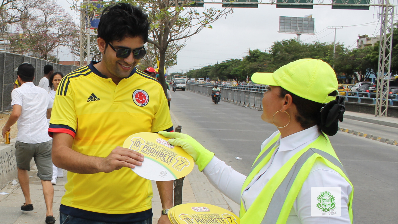 Orientadora entregando publicidad a aficionado.