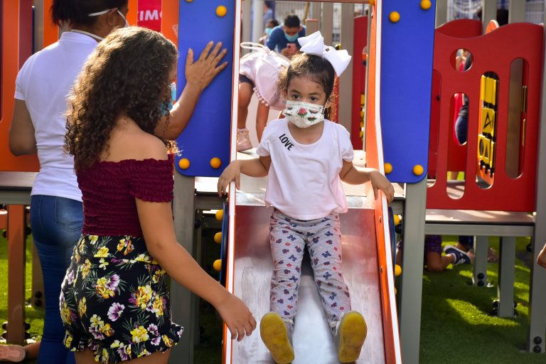 Niños jugando en parque infantil.