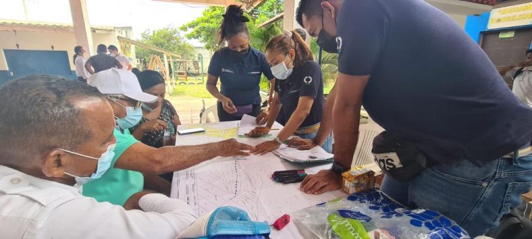 Funcionarios y asistentes observando mapa en la jornada de socialización.