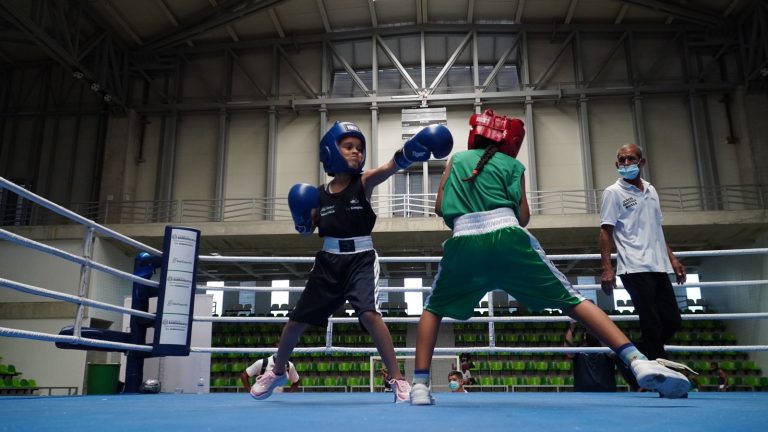 Niños practicando boxeo en ring.